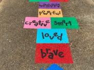 Volunteers hand painted an Empowerment Hopscotch in the interactive play area in Newberger Park